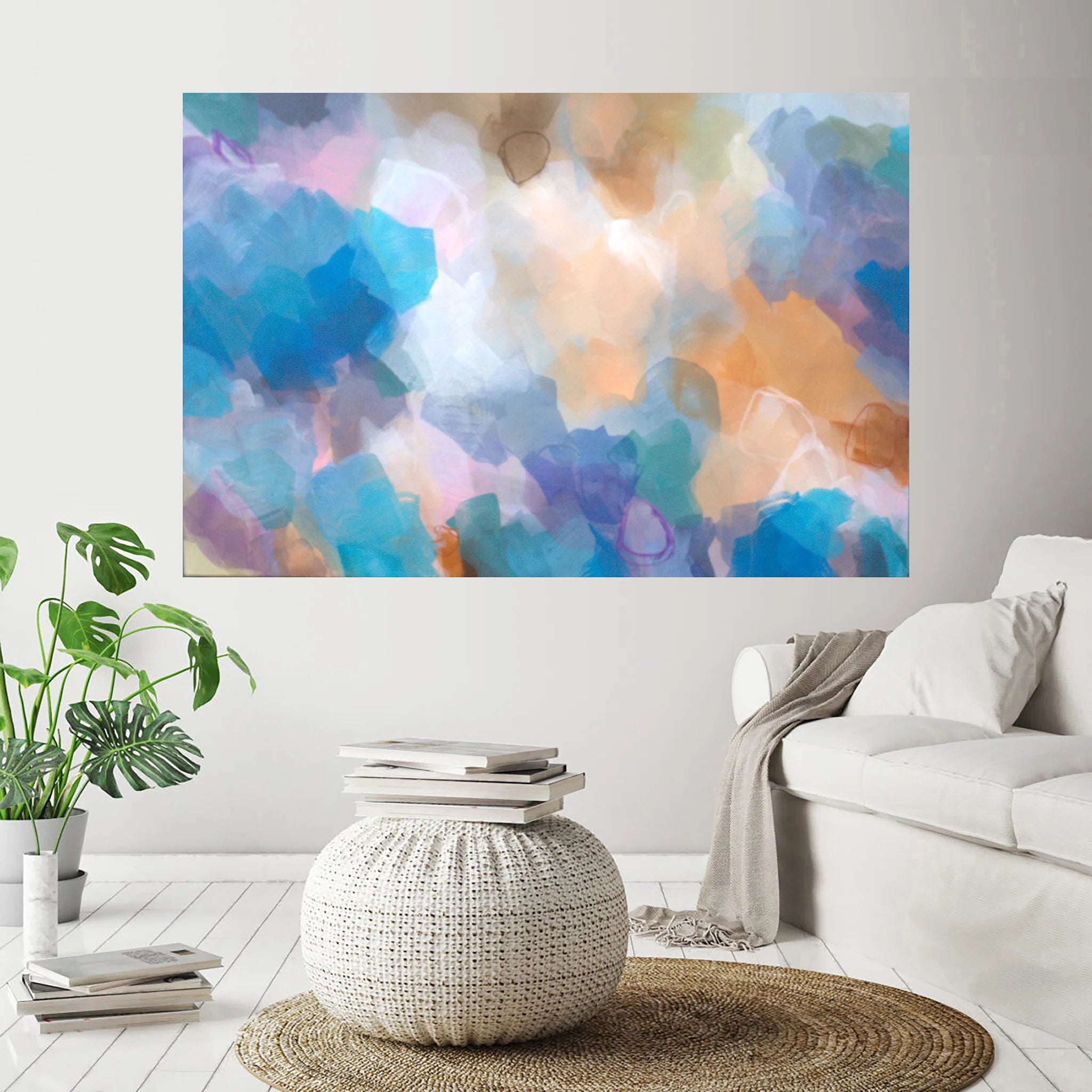 Colorful abstract painting on a wall above a white sofa and side table in a living room.