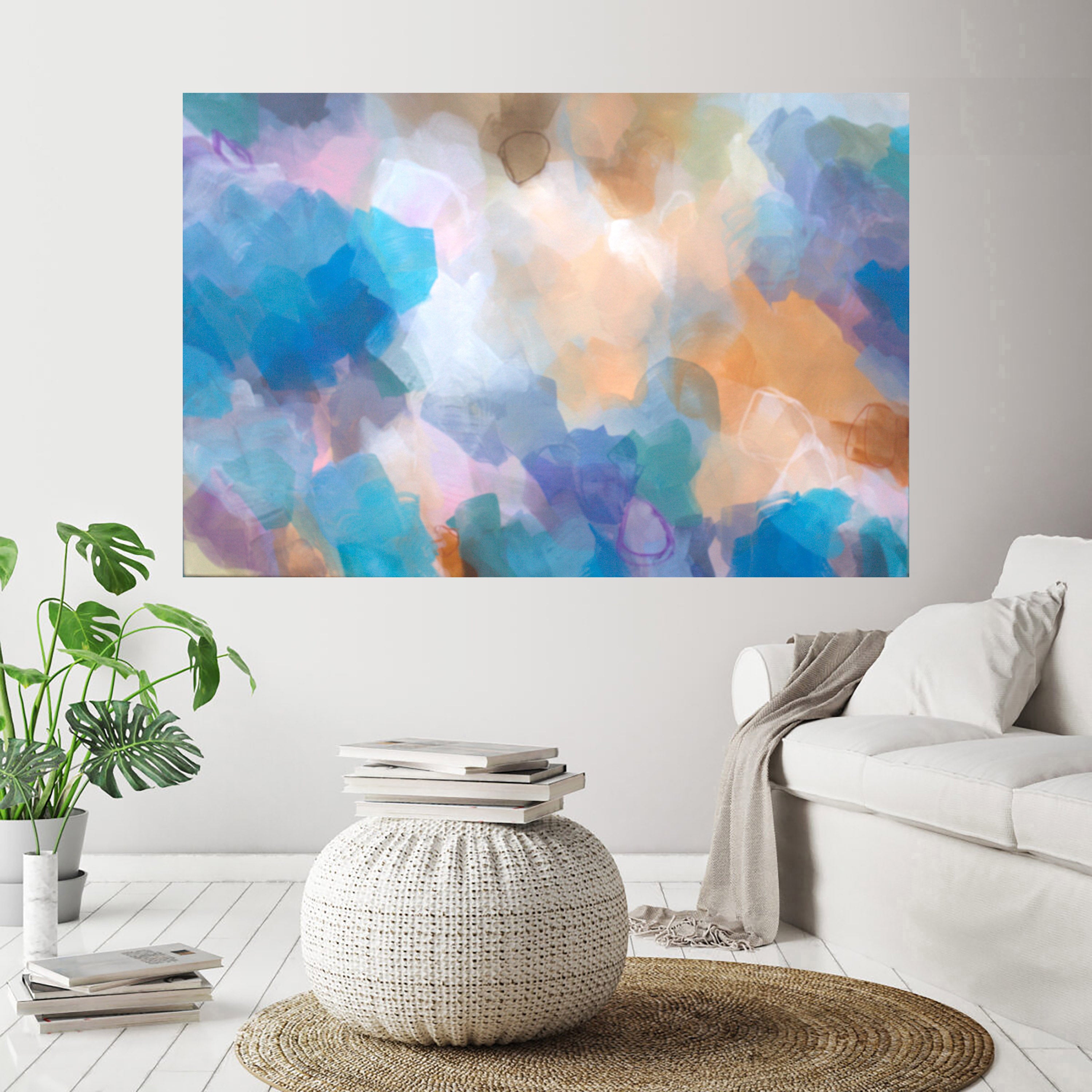 Colorful abstract painting on a wall above a white sofa and coffee table in a living room.