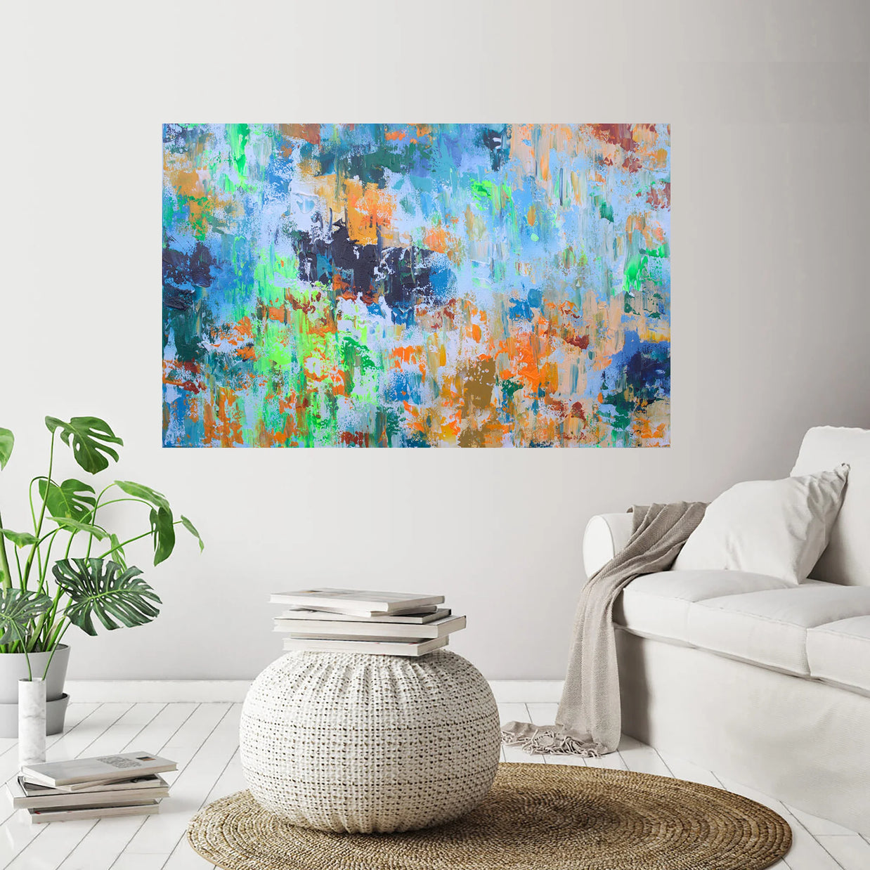 Abstract painting on a wall in a living room with a couch and plant.