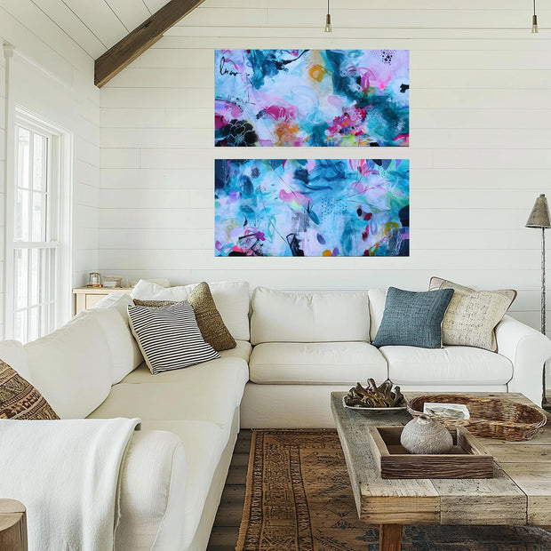 Living room with a white sofa, colorful abstract art on the wall, and a wooden coffee table.