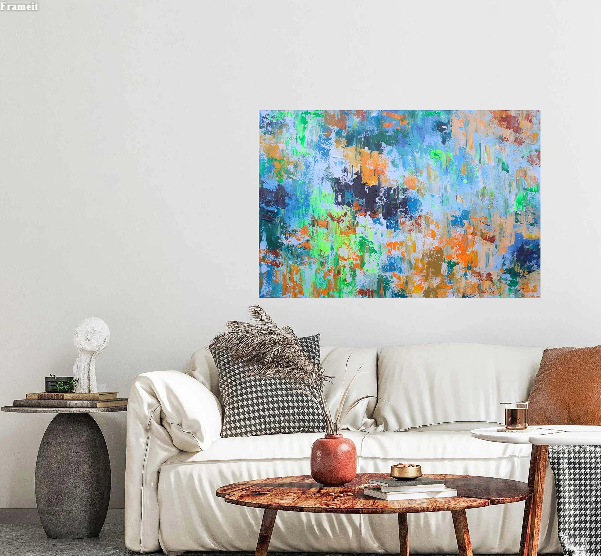Colorful abstract painting on a wall above a white sofa with decorative pillows.