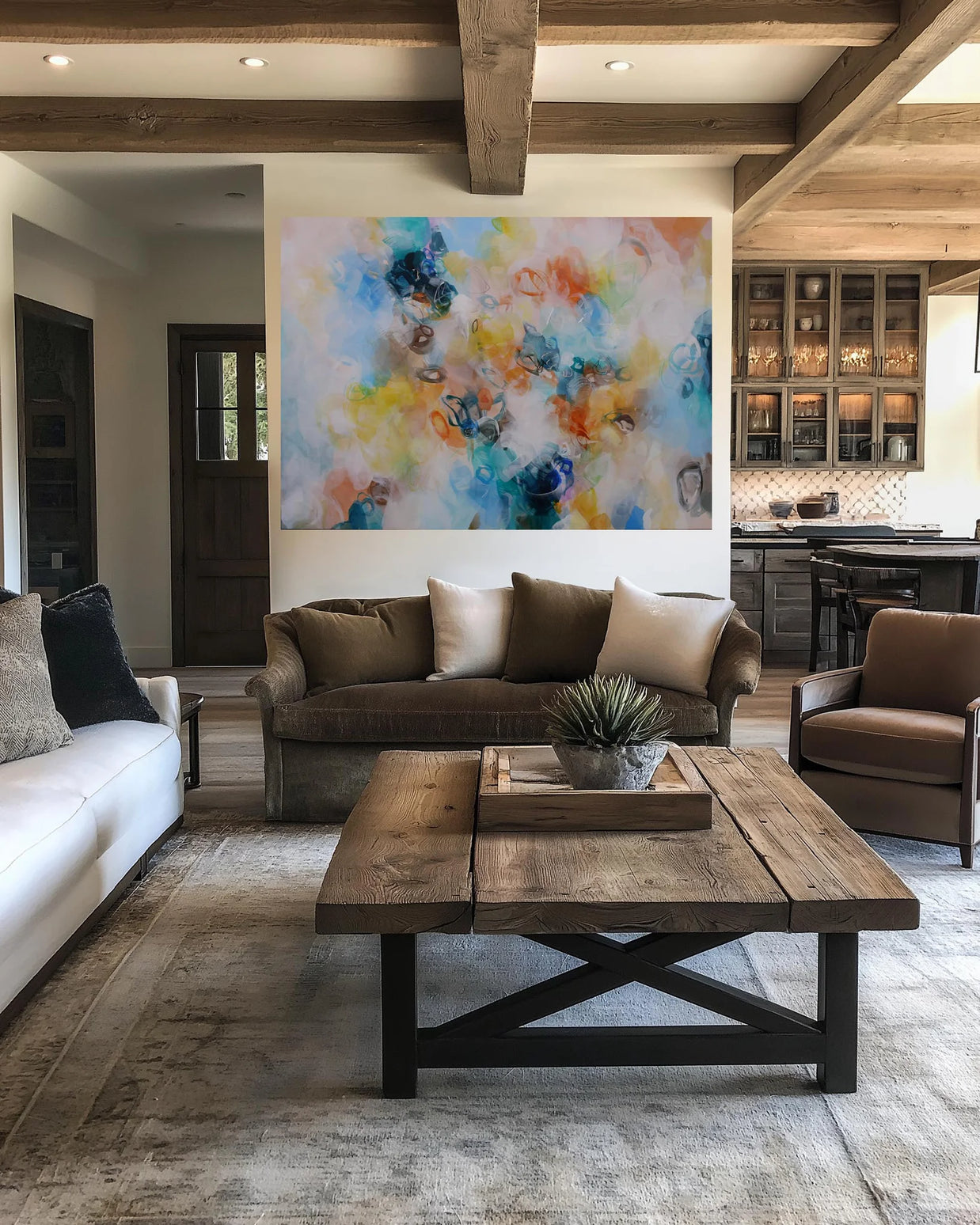 Modern living room with a brown sofa, white walls, and a colorful abstract painting.