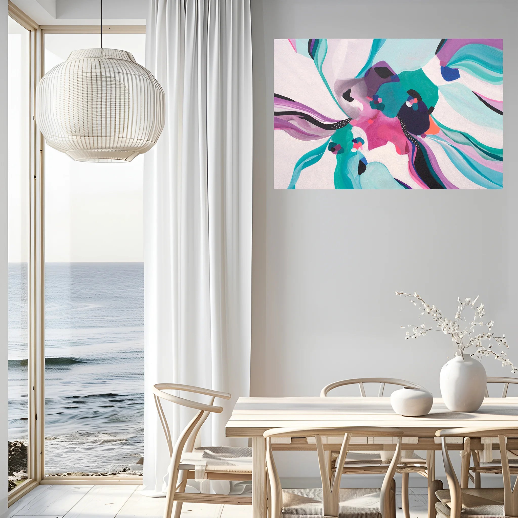 Modern interior with a colorful abstract painting on the wall, a dining table, and a view of the ocean.