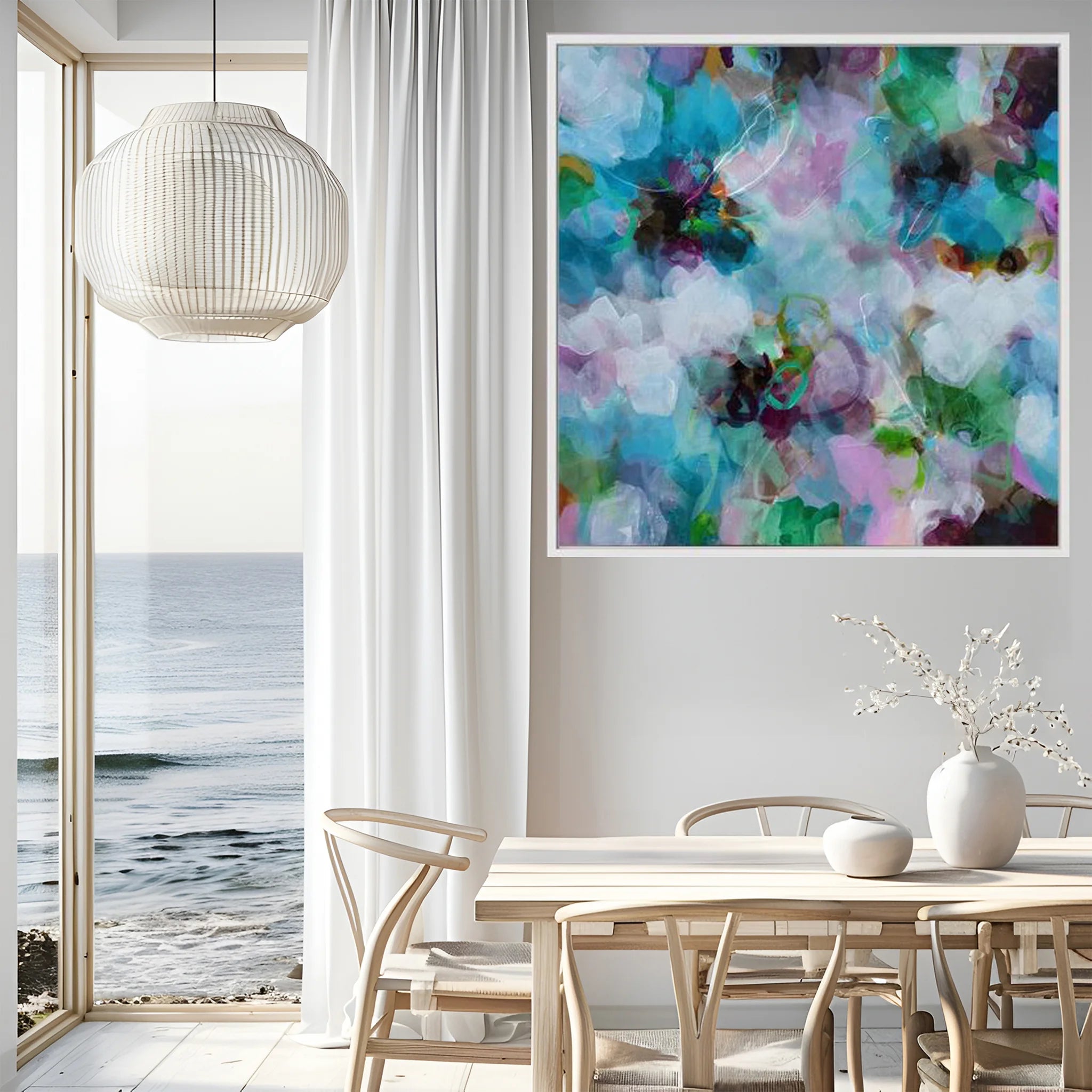 Modern interior with a colorful abstract painting on the wall, a dining table, and a view of the ocean.