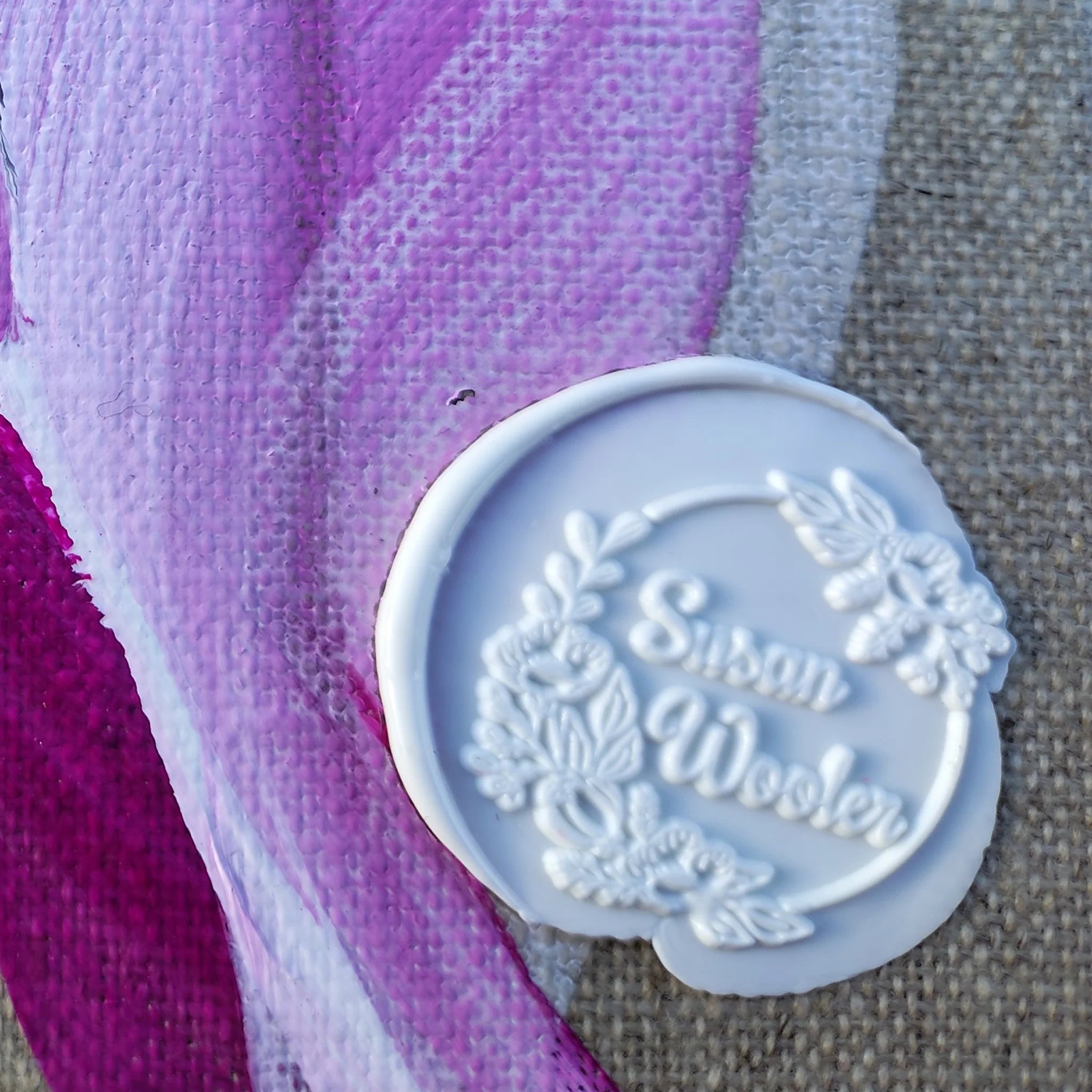 Floral inspired abstract art, purple, lilac, mauve white, charcoal and grey on a linen canvas close up of wax signature