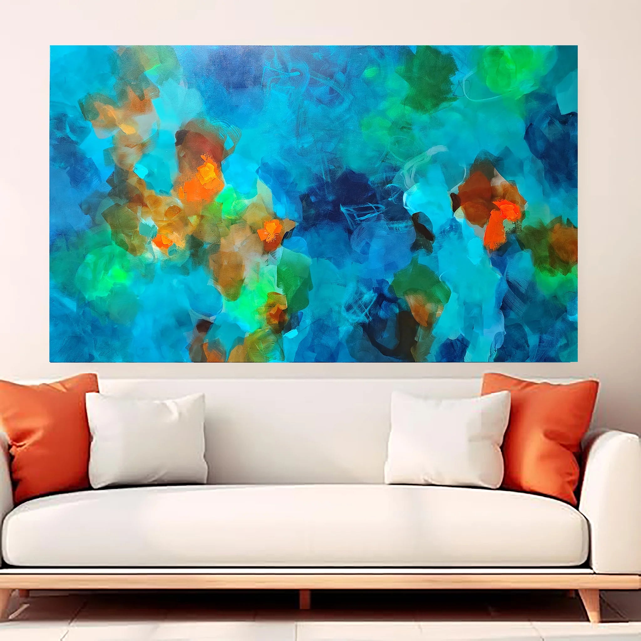 Colorful abstract painting on a wall above a white sofa with orange and white cushions.