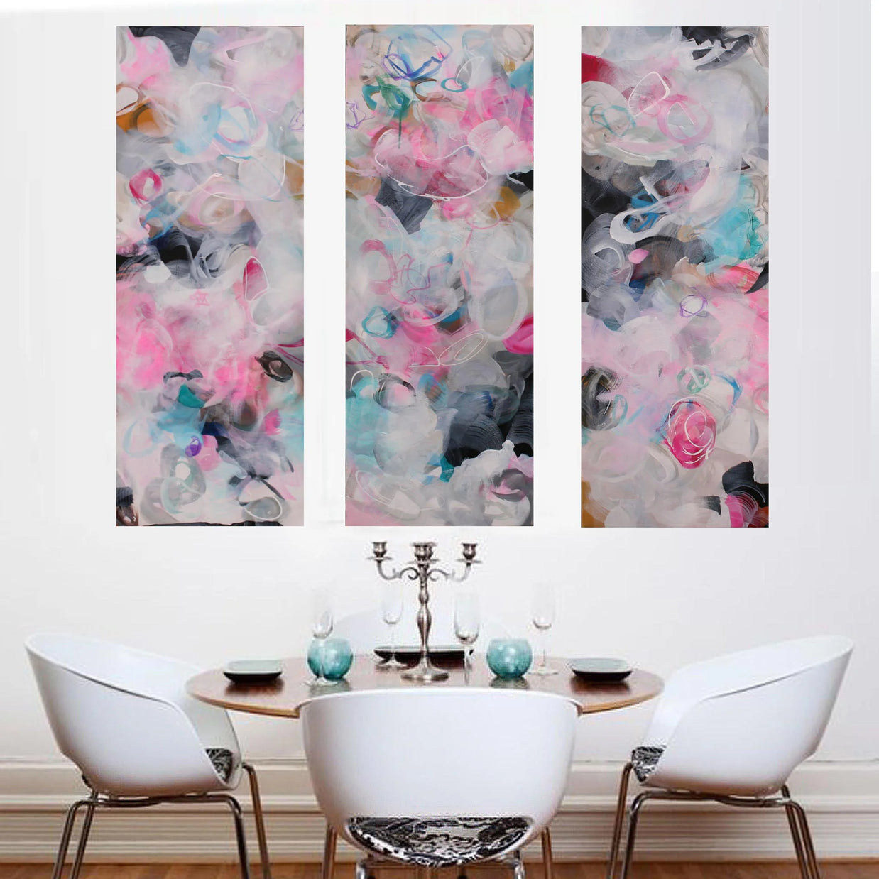Pink, blue, white, grey, black three panel abstract painting hanging above dining table