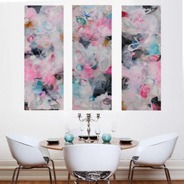 Pink, blue, white, grey, black three panel abstract painting hanging above dining table