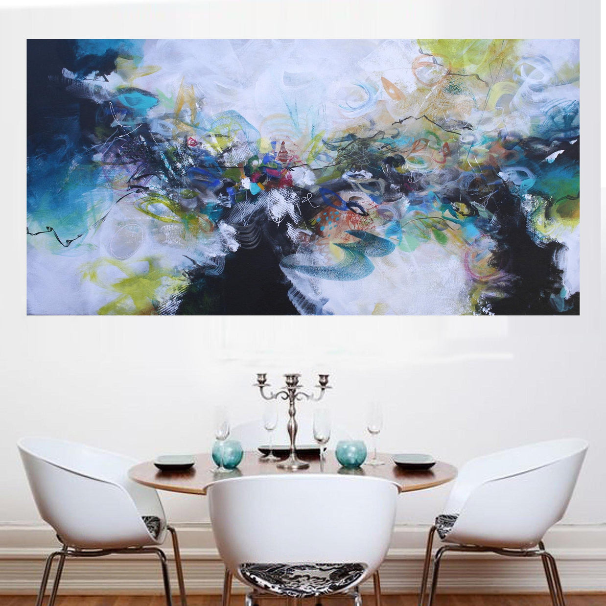 Abstract painting above a dining table with chairs