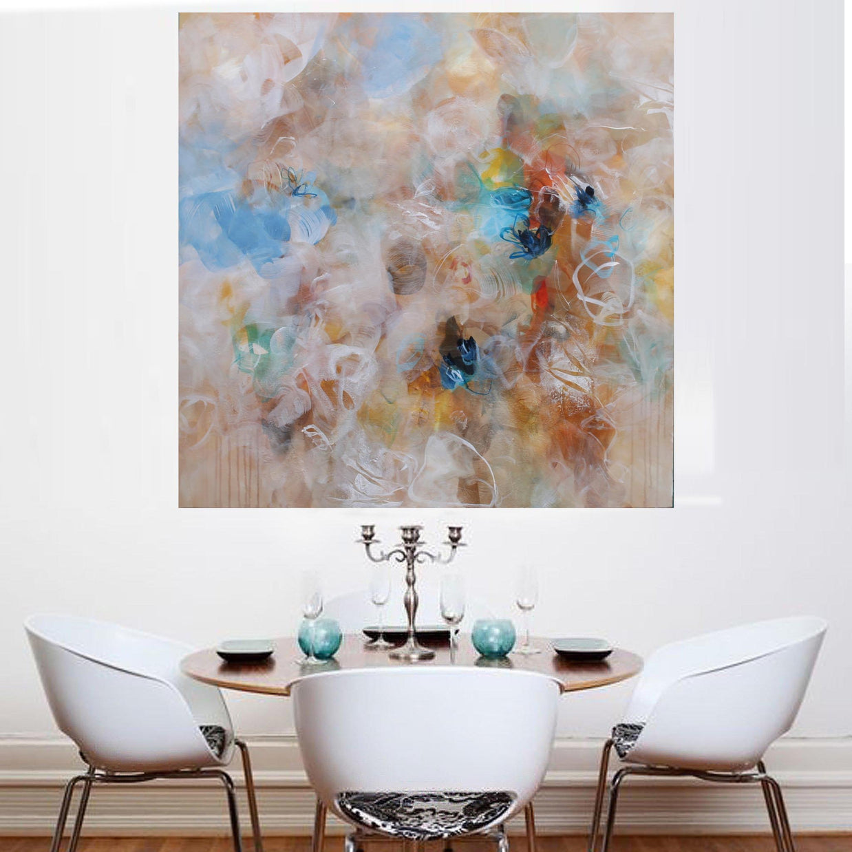 Abstract painting in a dining room with a round table and chairs.