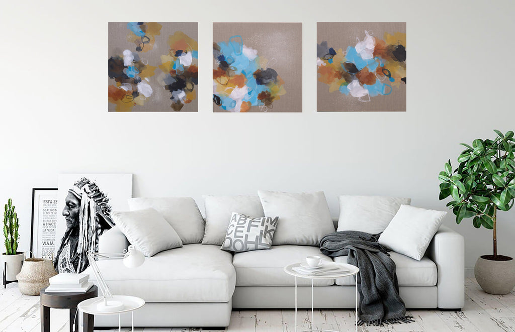 Living room with a white sofa, abstract wall art, and indoor plants.