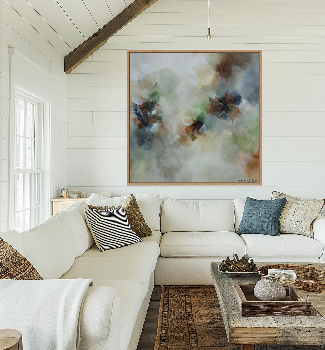 Living room with a white sofa, decorative pillows, and a large abstract painting on the wall.