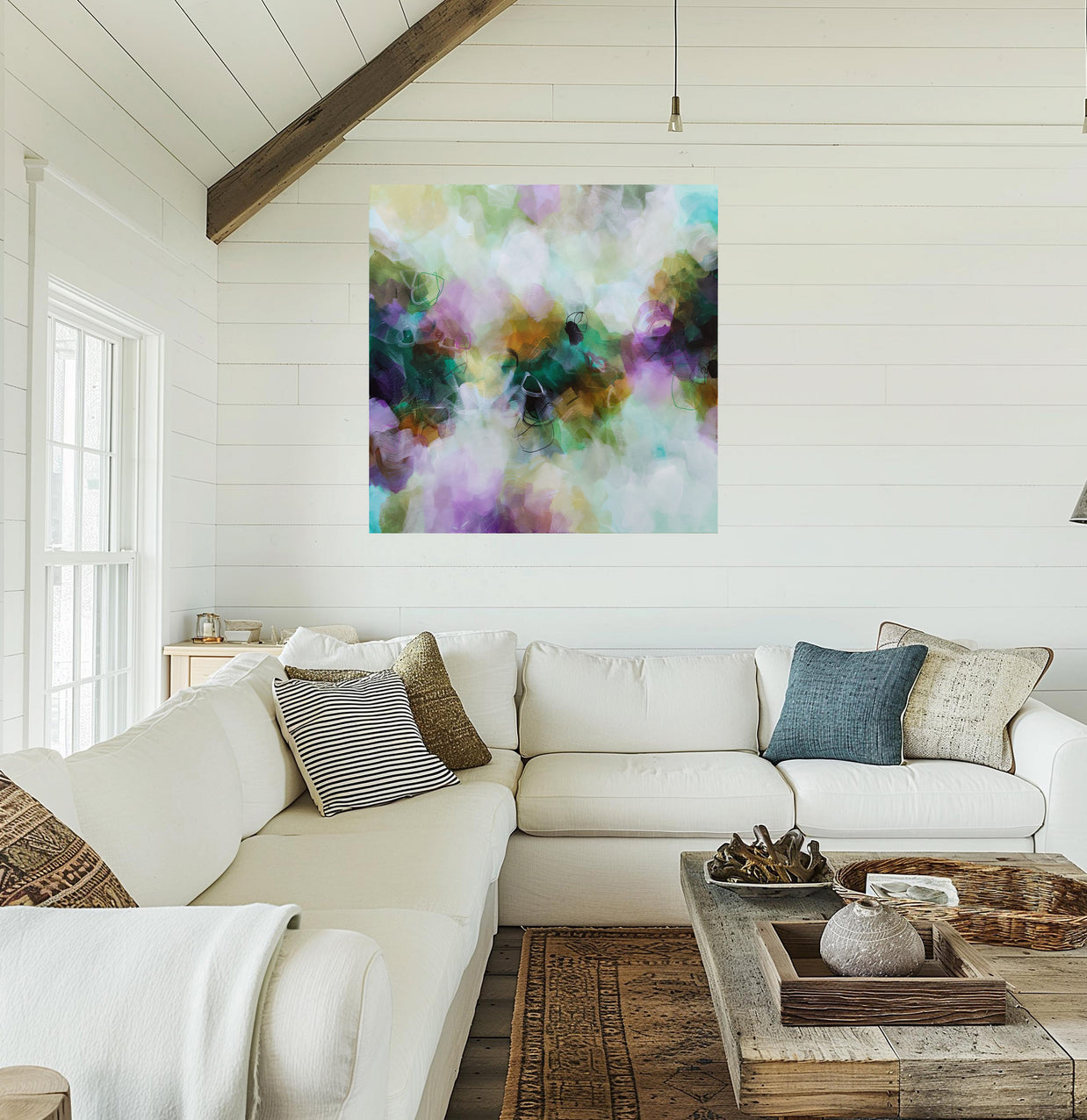 Living room with a white sofa, colorful abstract painting, and wooden coffee table.