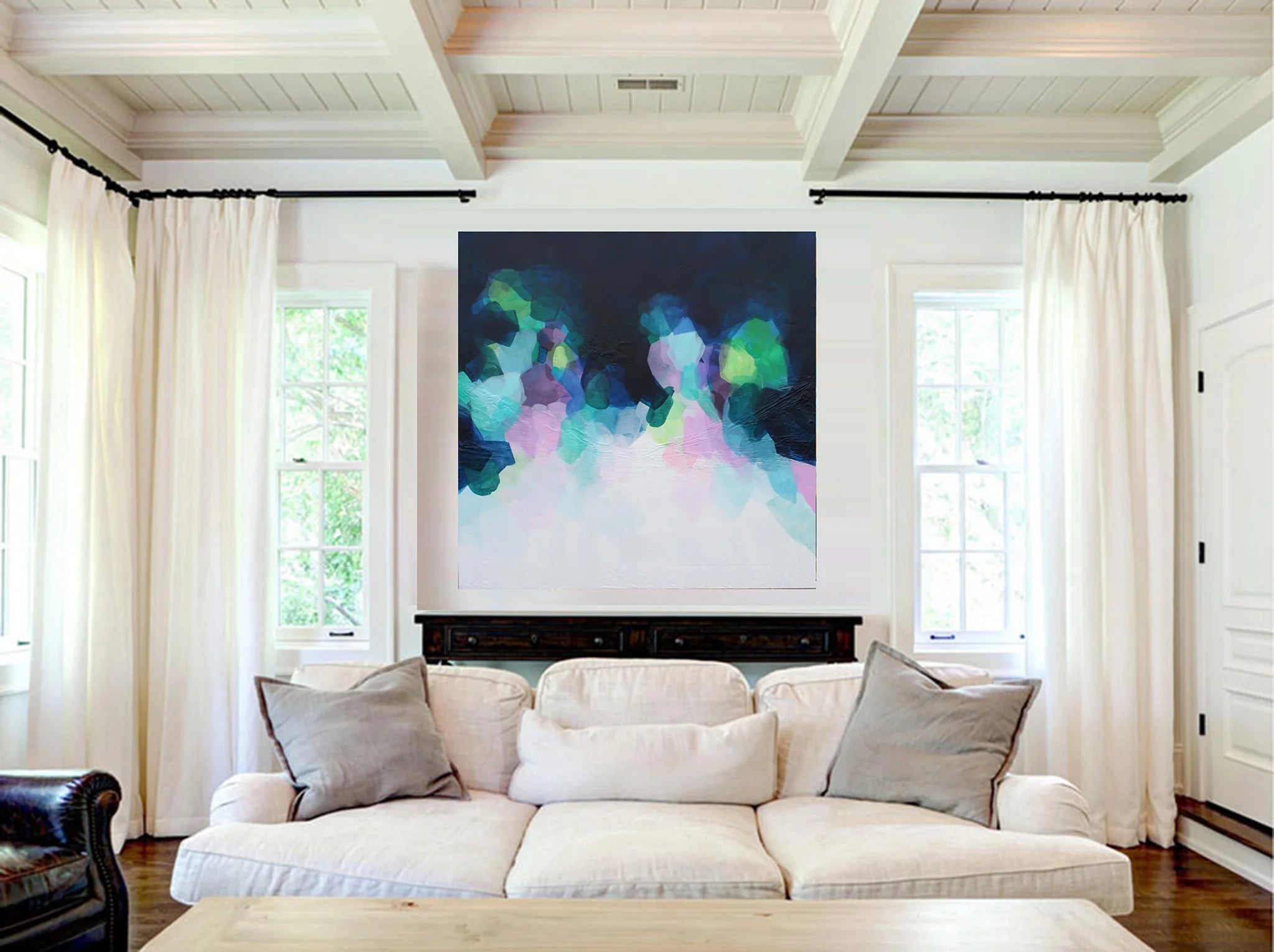 Living room with a white sofa, colorful abstract painting above the fireplace, and white curtains.