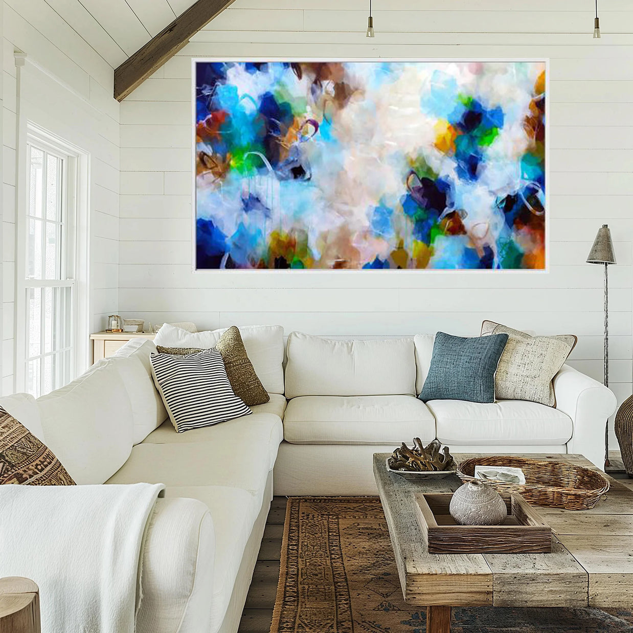 Living room with a white sofa, colorful abstract painting, and wooden coffee table.