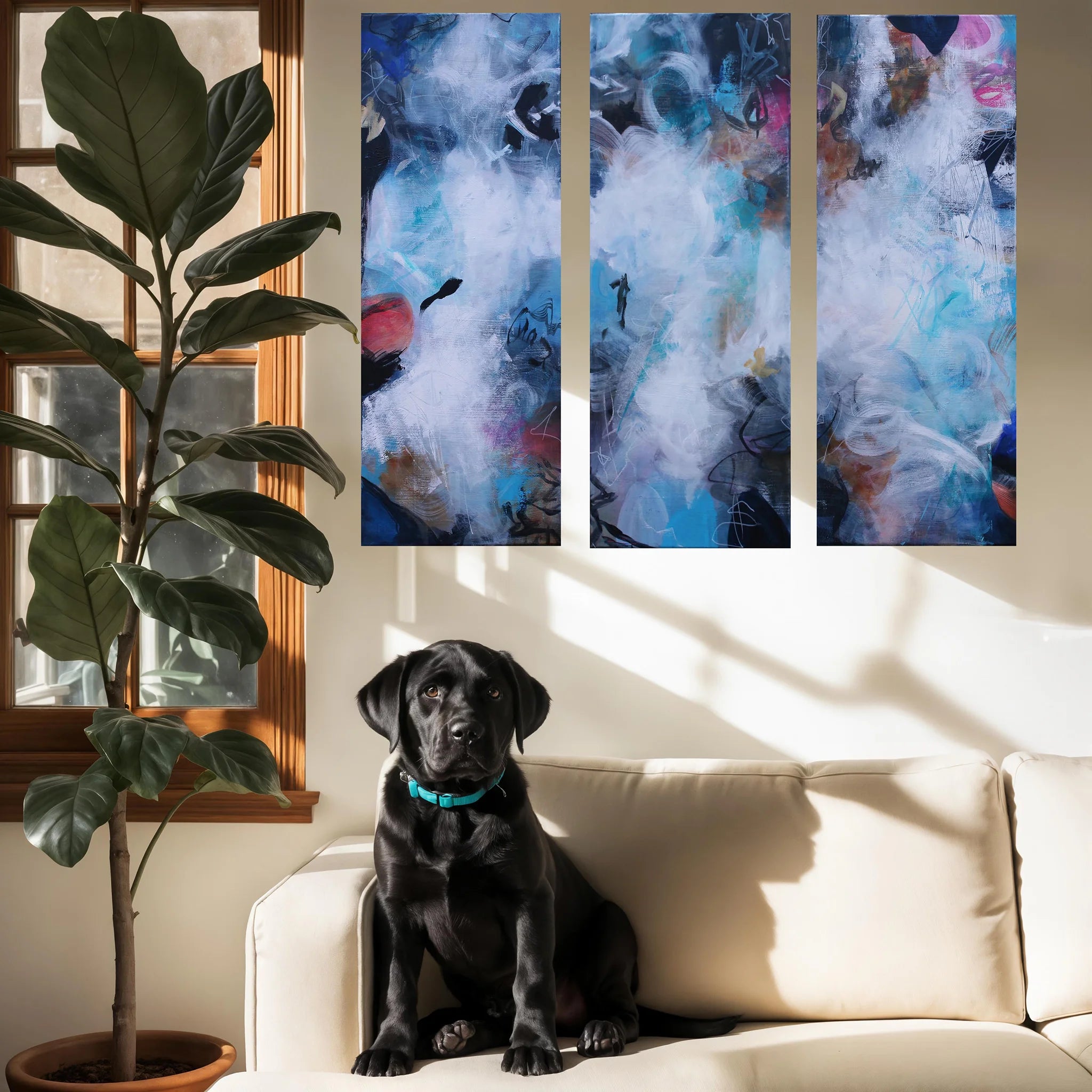 Black dog sitting on a beige couch with abstract art above and a potted plant to the left.