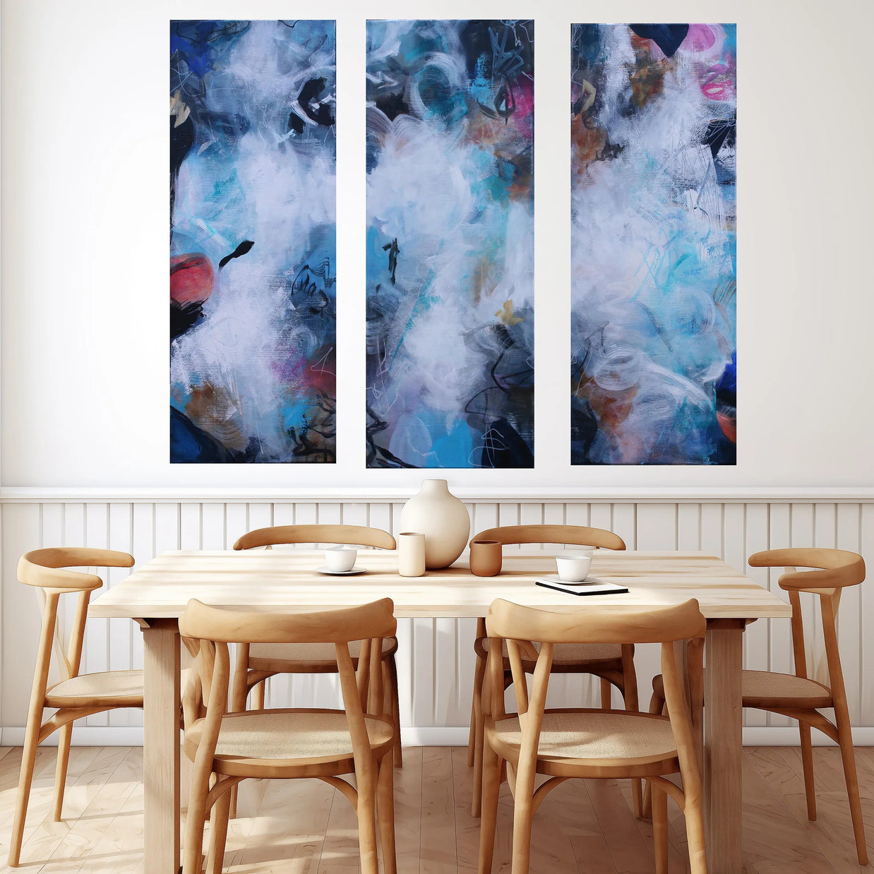 colorful abstract 3 panel painting hanging above dining table and chairs