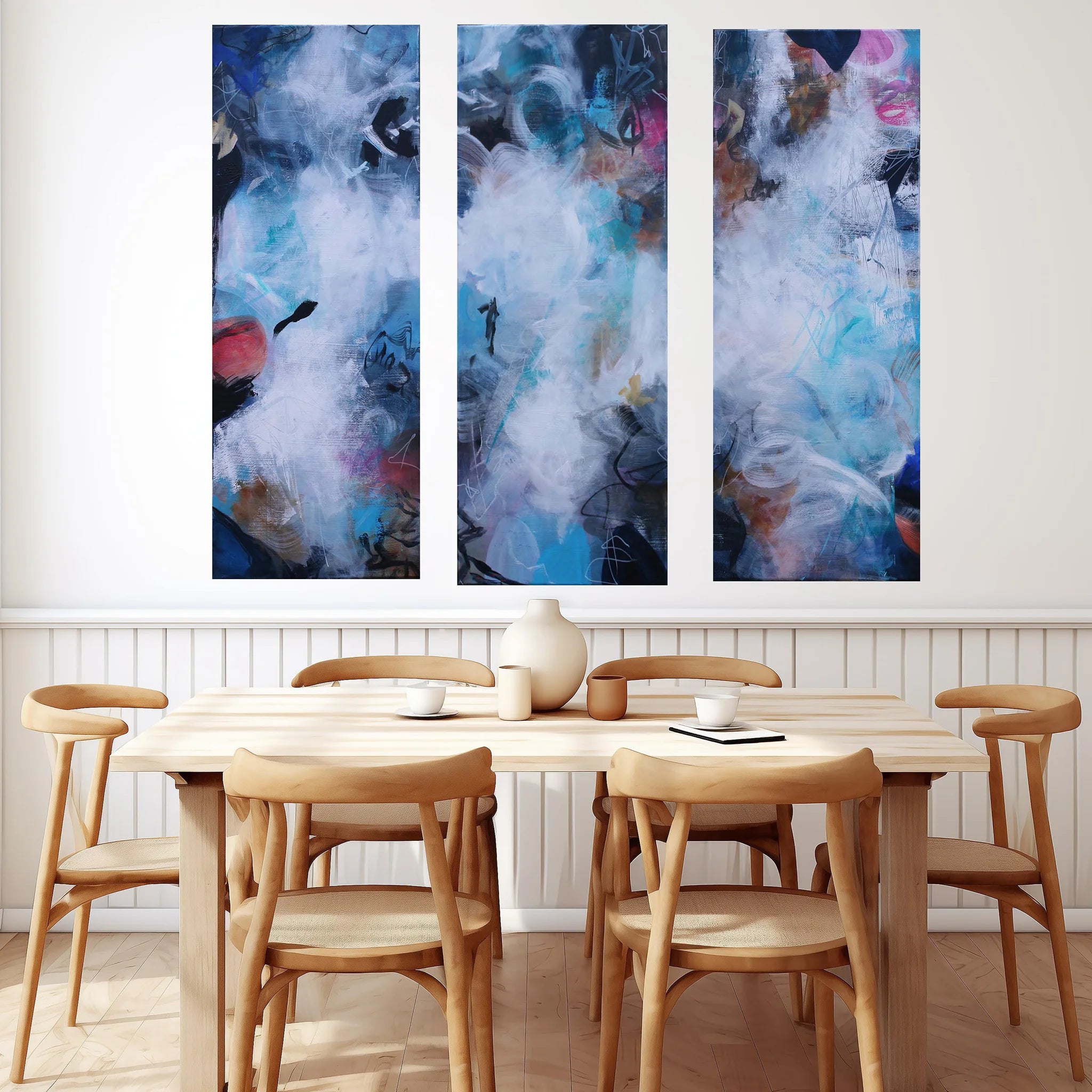 colorful abstract 3 panel painting hanging above dining table and chairs
