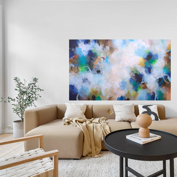 Modern living room with a beige sectional sofa, abstract artwork, and decorative items.