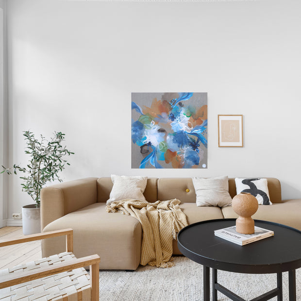 Modern living room with a beige sectional sofa, round black coffee table, and abstract artwork on the wall.