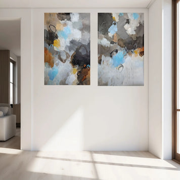 Two abstract paintings on a wall in a modern living room.