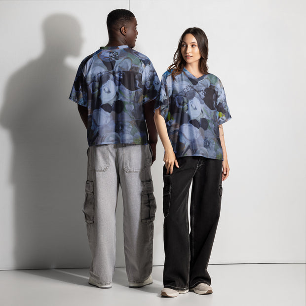 Two people wearing matching patterned shirts and pants against a white background