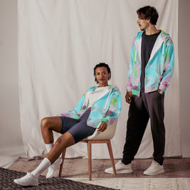 Two people wearing colorful jackets in a studio setting
