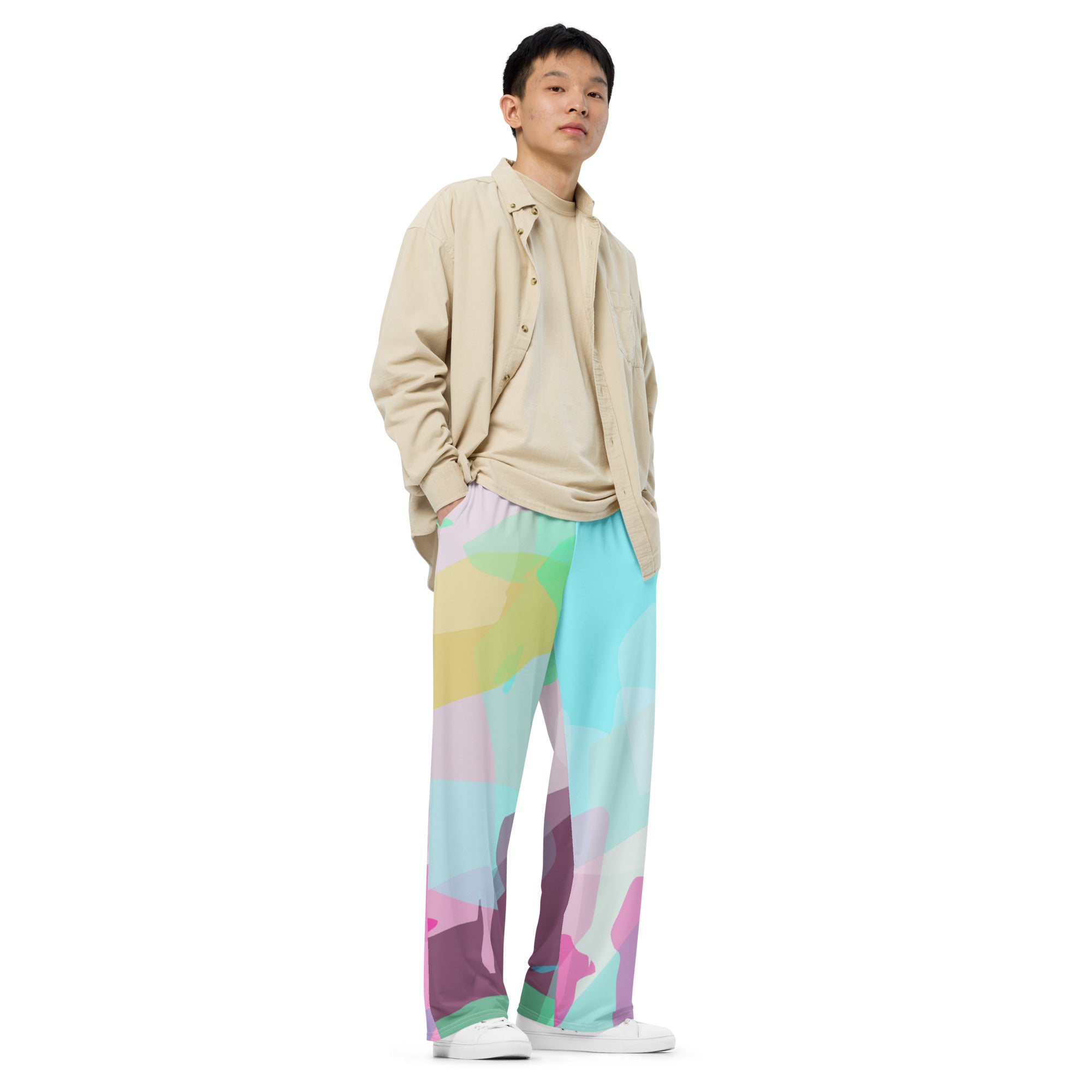 Person wearing a beige shirt and colorful pants on a white background