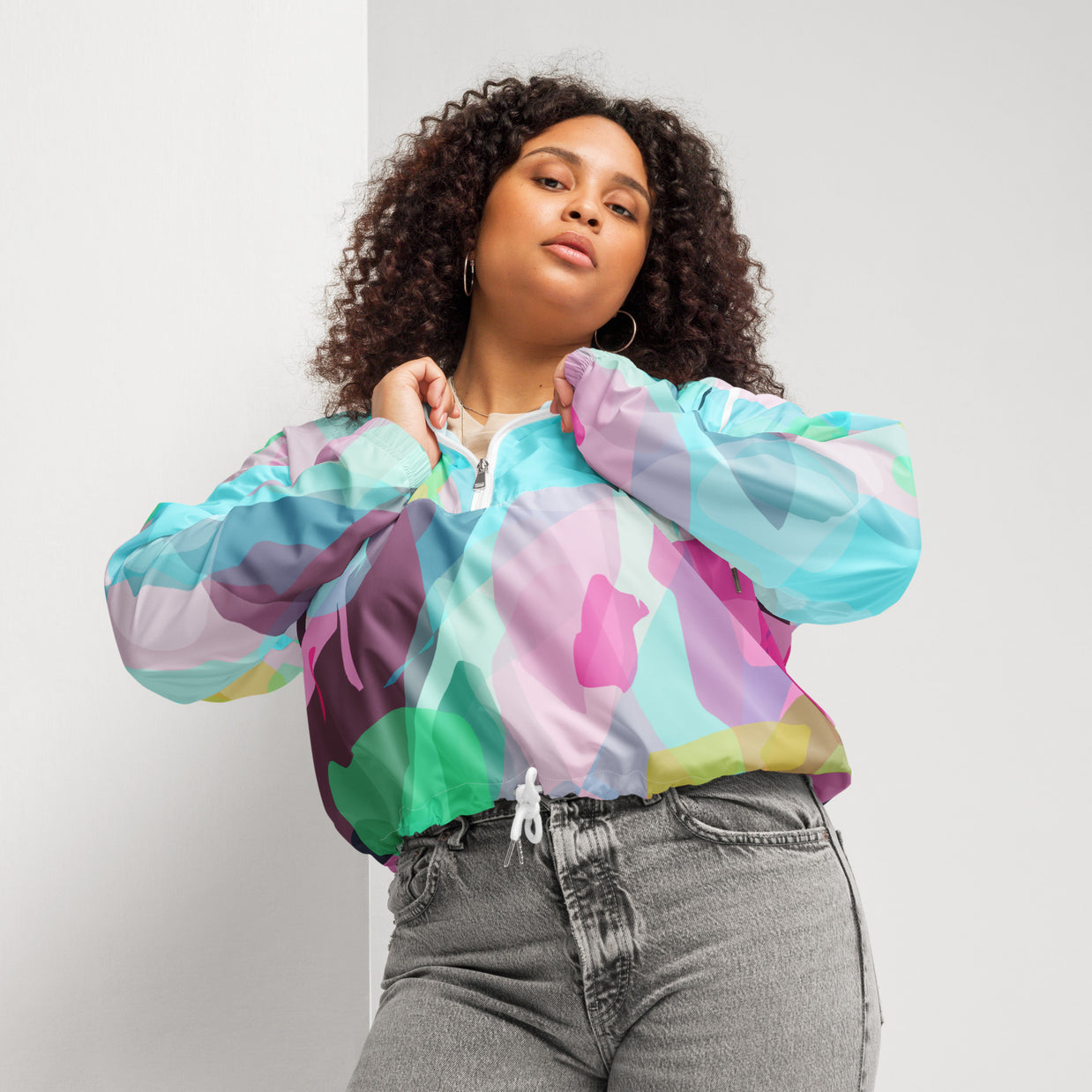 Person wearing a colorful tie-dye jacket with a plain background