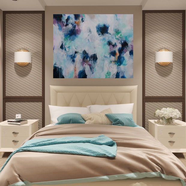Modern bedroom with abstract art, beige headboard, and nightstands.