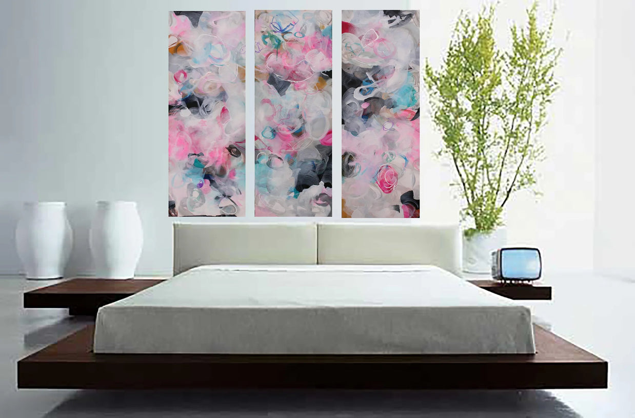 Pink, blue, white, grey, black three panel abstract painting hanging above bed 