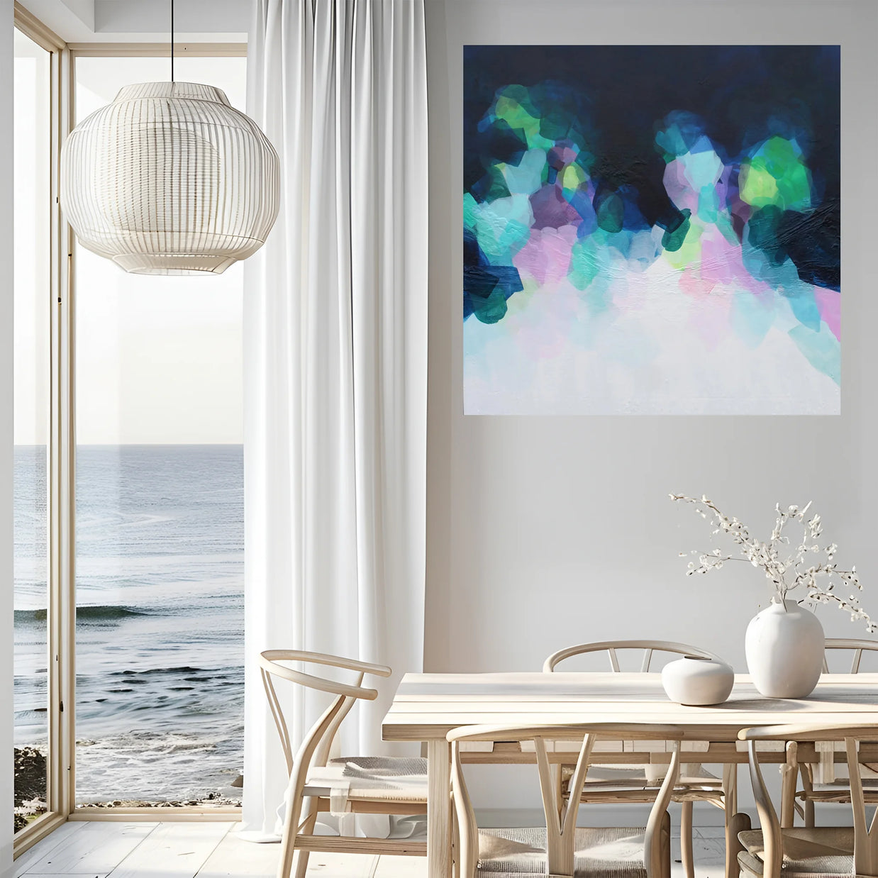 Modern dining room with a colorful abstract painting on the wall, a table, chairs, and a view of the ocean.