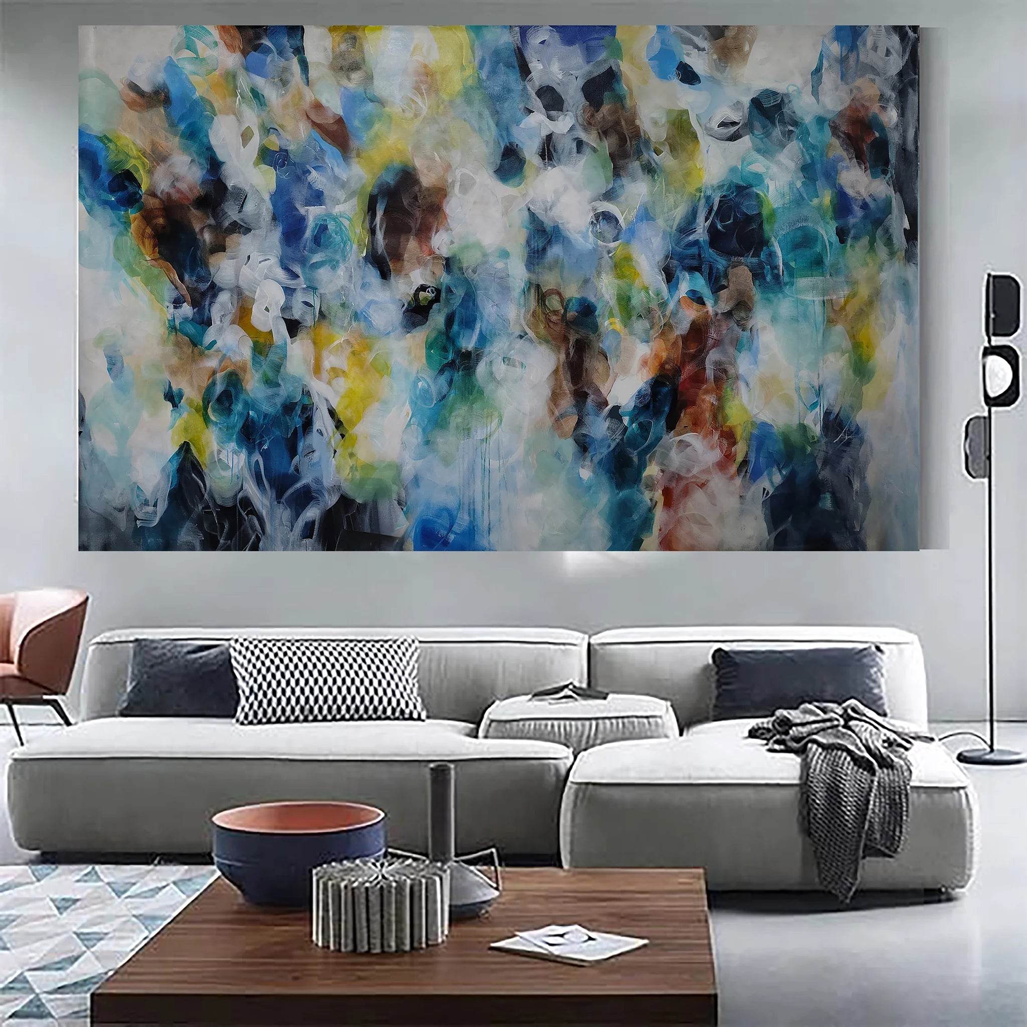 Modern living room with a large abstract painting on the wall above a gray sofa.