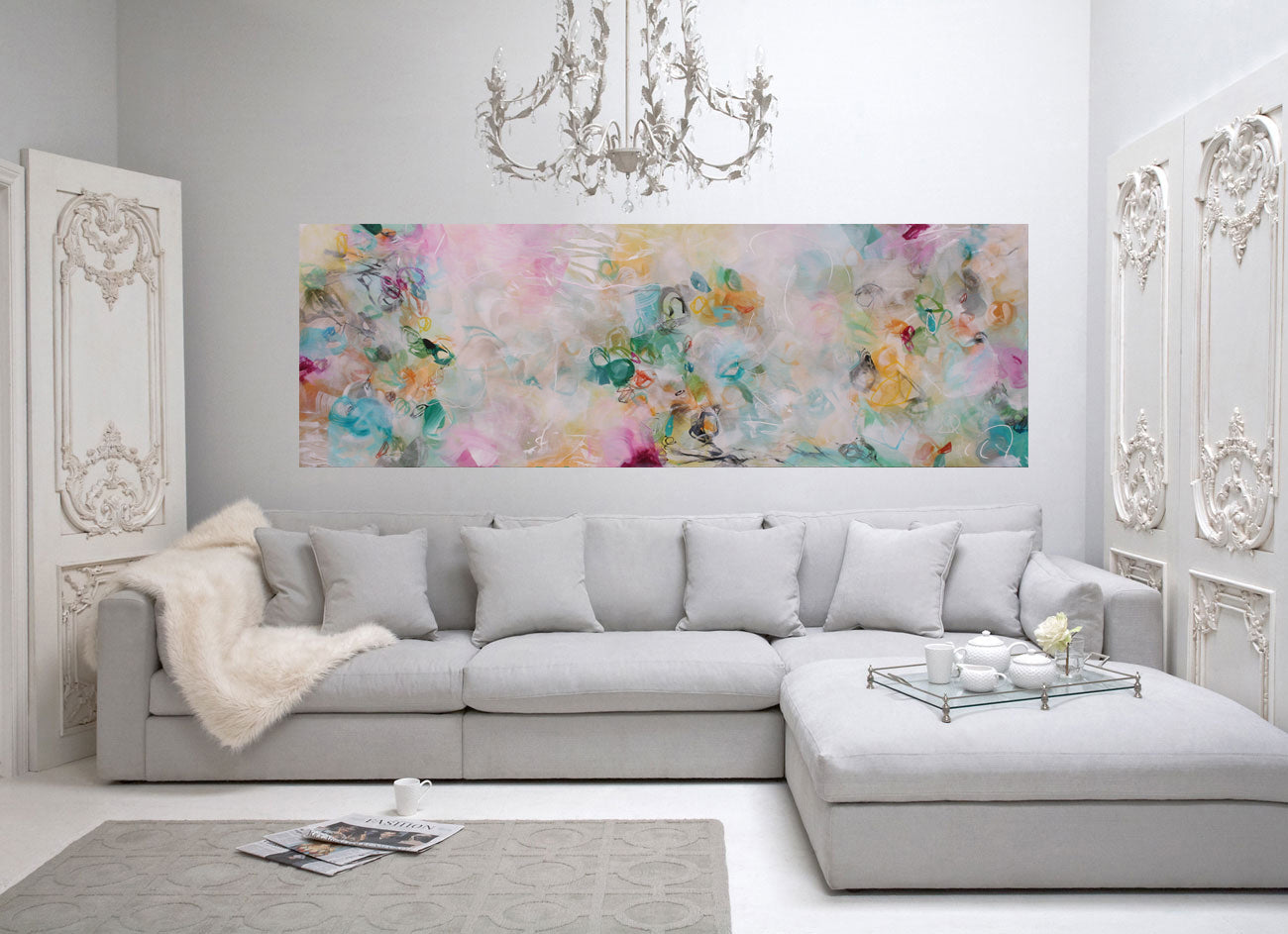 Living room with a gray sectional sofa, floral artwork, and decorative elements.