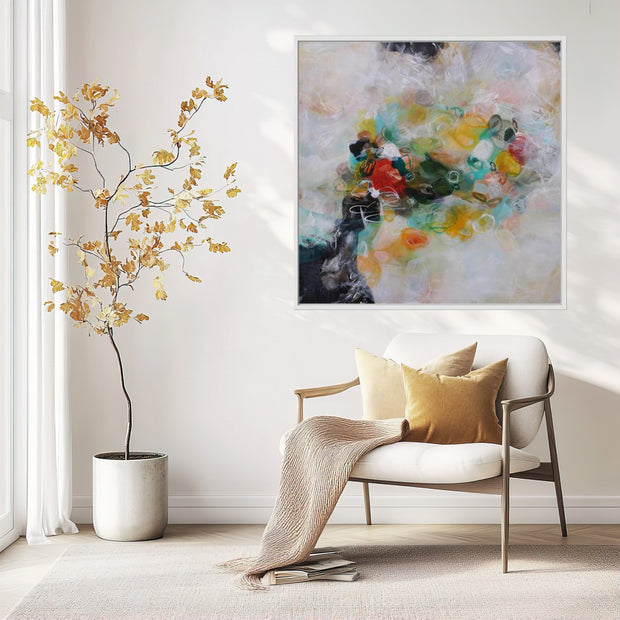 Modern living room with a white armchair, abstract painting, and decorative plant.