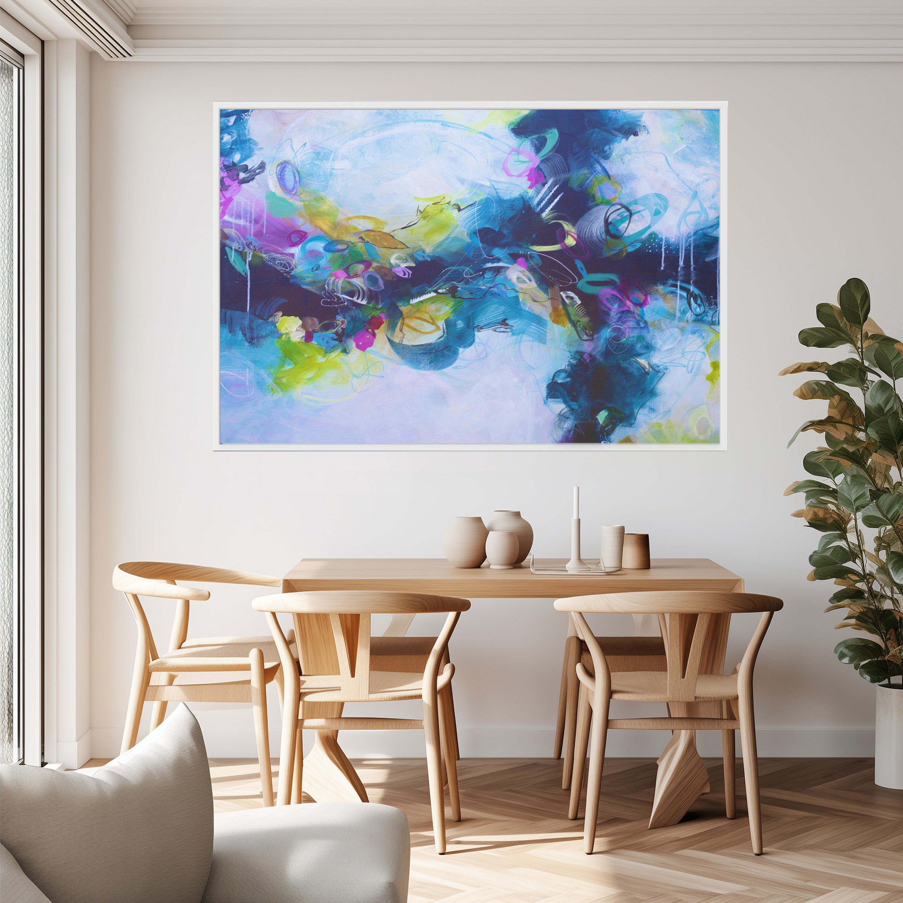 Dining room with a colorful abstract painting on the wall above a wooden table.