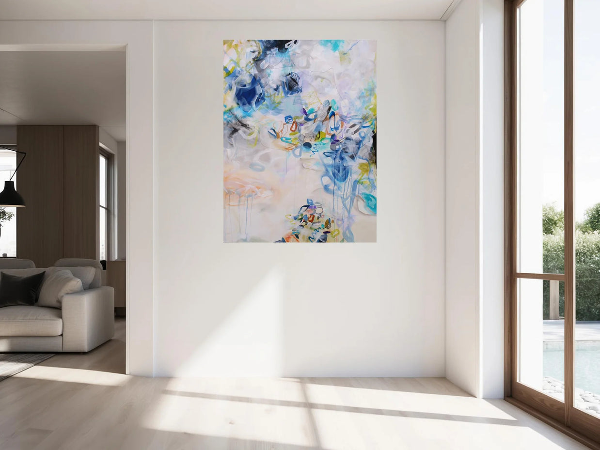 Colourful blue, white, yellow and green abstract painting hanging on wall