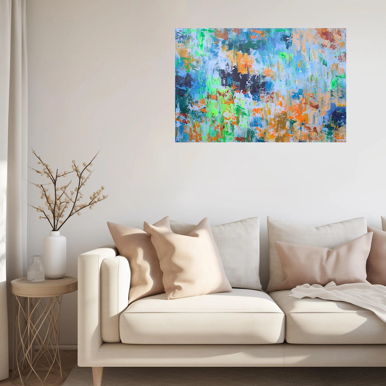 Colorful abstract painting on a wall above a beige sofa with decorative pillows.