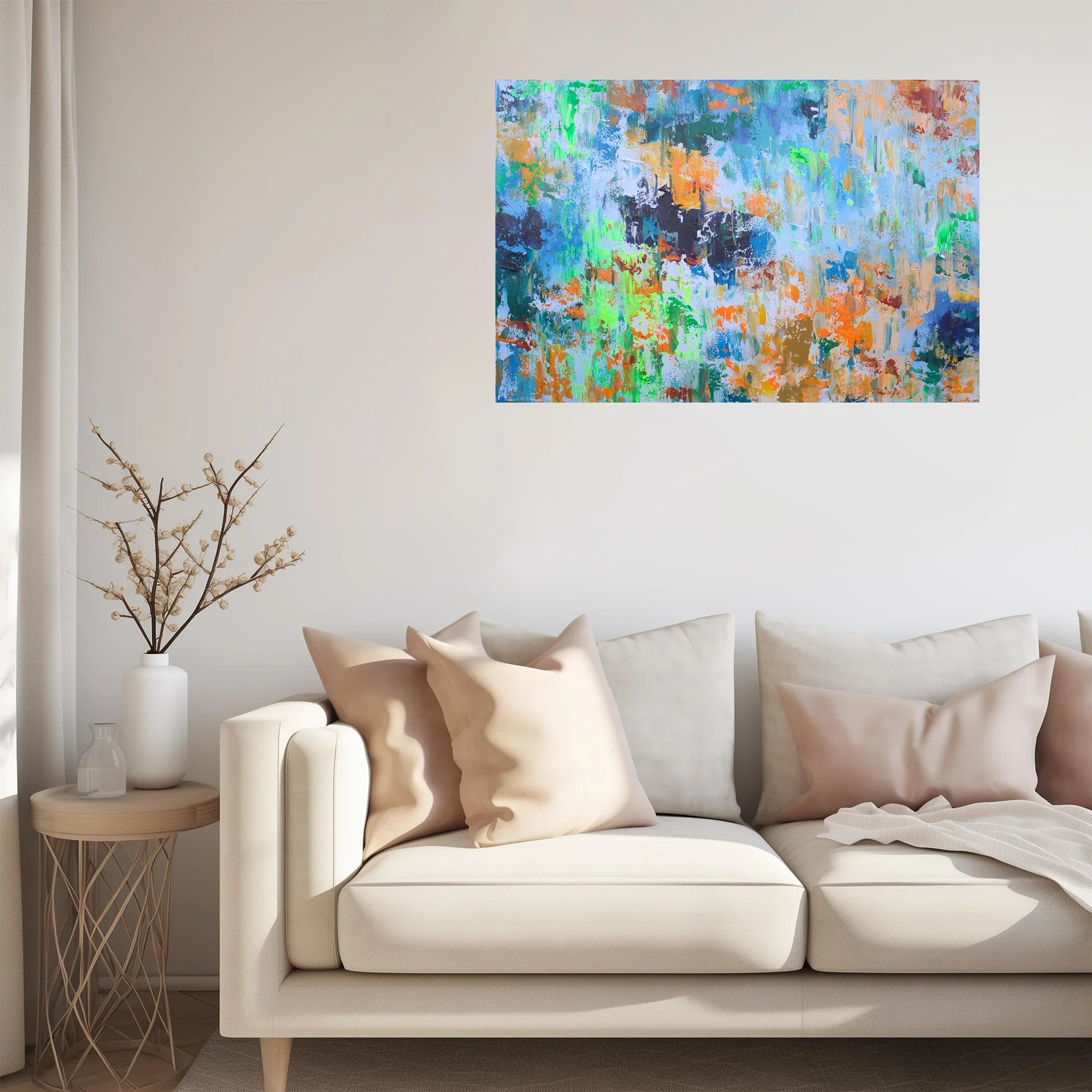 Colorful abstract painting on a wall above a beige sofa with decorative pillows.