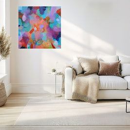 Modern living room with a colorful abstract painting on the wall above a white sofa.