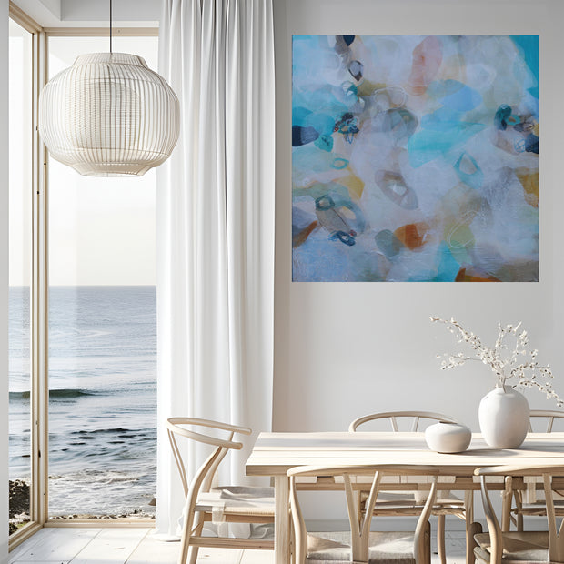 Modern interior with abstract art, table, chairs, and ocean view.