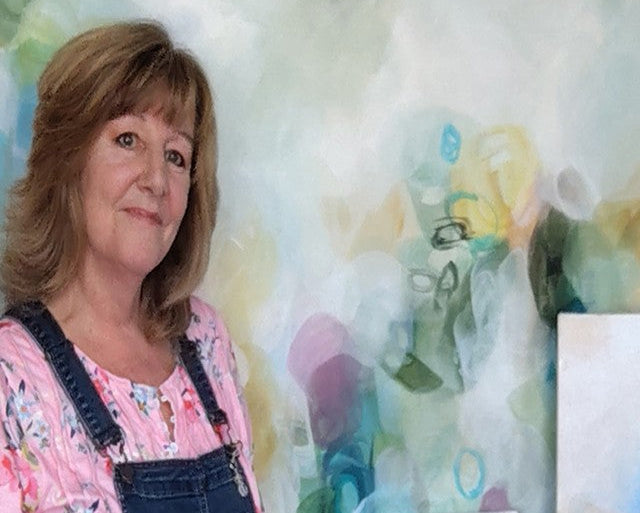 Woman standing in front of a colorful abstract painting