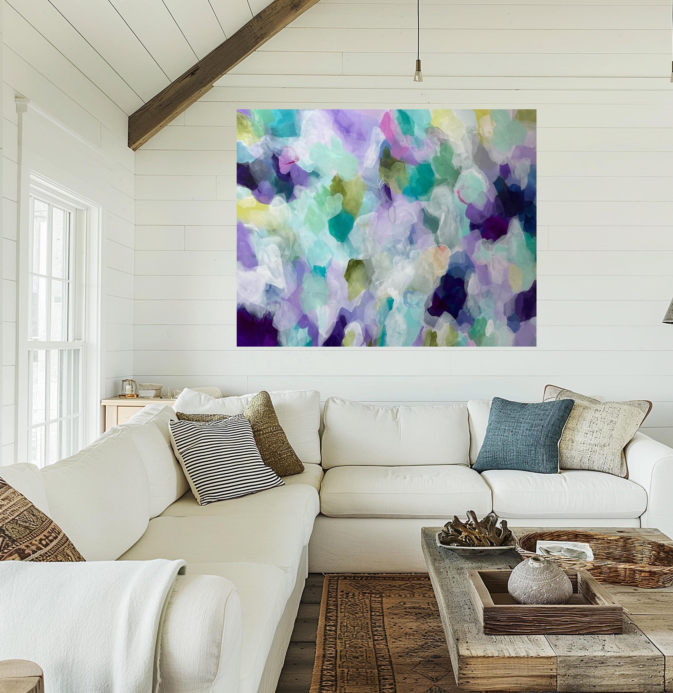 Living room with a white sofa, colorful abstract painting on the wall, and wooden coffee table.