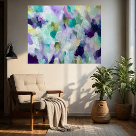 Living room with a colorful abstract painting on the wall, a chair with a blanket, and two potted plants.