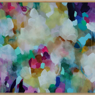 An abstract framed painting with a colorful watercolor-like composition featuring white, pink, purple, green, blue, and yellow tones, enclosed in a light wood frame.