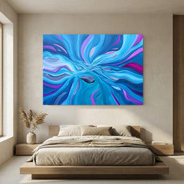 A large square abstract wall art print hangs above a low wooden platform bed in a minimalist beige bedroom. The artwork features swirling, fluid-like bands of bright blue, purple, and pink with a dark blue central form.