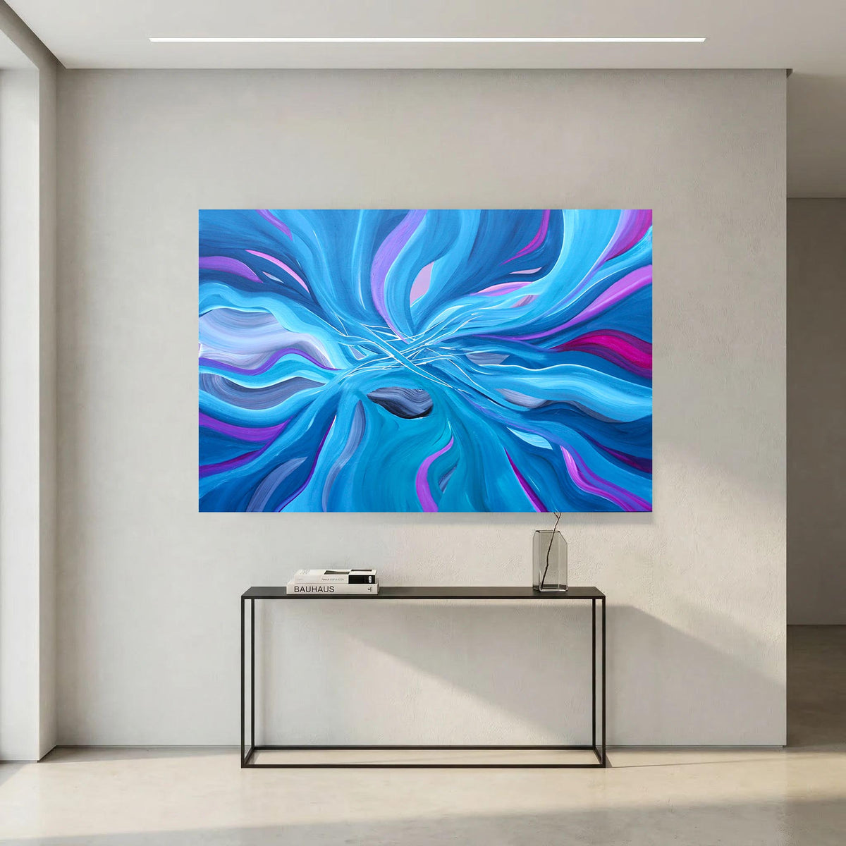 A large square abstract wall art print with swirling blue, purple, and cyan patterns, displayed above a black console table in a minimalist modern room.
