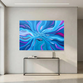 A large square abstract wall art print with swirling blue, purple, and cyan patterns, displayed above a black console table in a minimalist modern room.