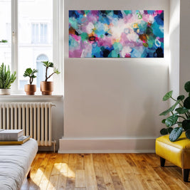 Living room with a colorful abstract painting on the wall, plants, and a yellow chair.