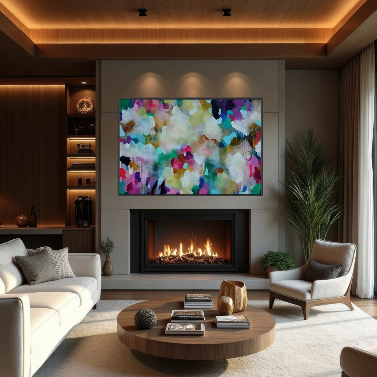 A large abstract canvas print with vibrant multicolored brushstrokes hangs above a modern fireplace in a contemporary living room setting with a white sofa, wooden coffee table, and armchair.
